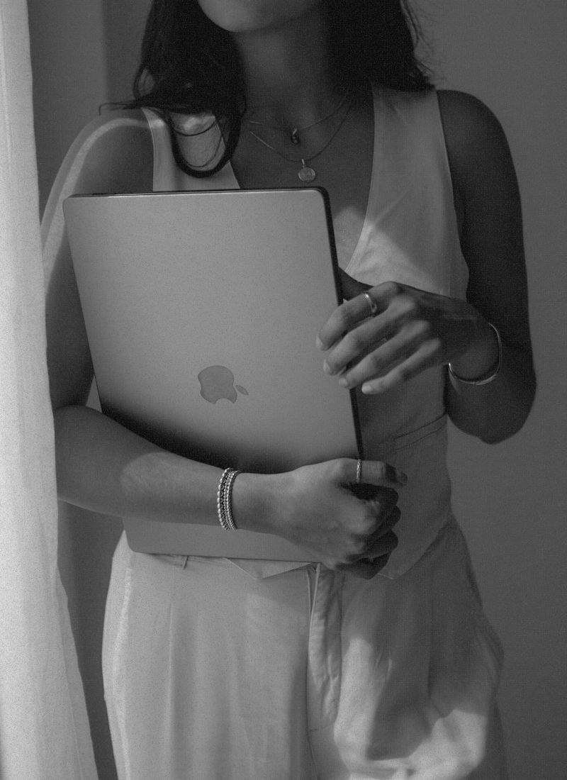 A professional woman holding a laptop, ready to navigate the complexities of paid and organic traffic strategies in the digital marketing realm.