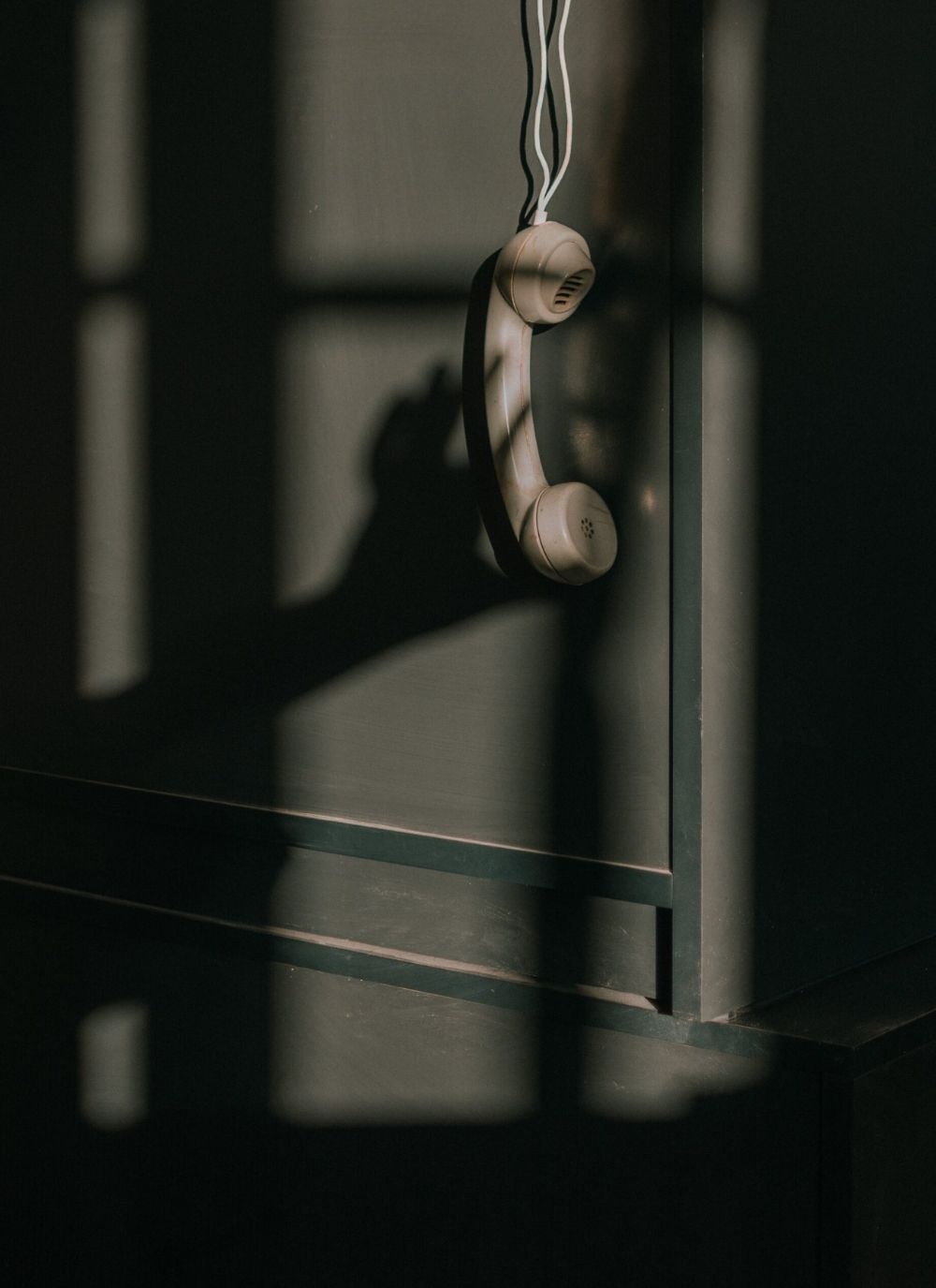 Disconnected phone handset in shadows, representing the power of saying no in business to protect creative energy.