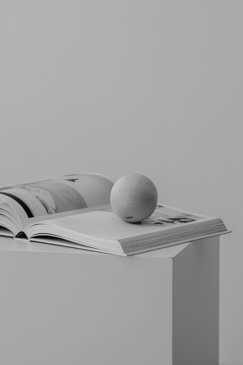 wooden ball laying on an open book